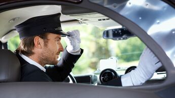Elegant chauffeur in luxurious car