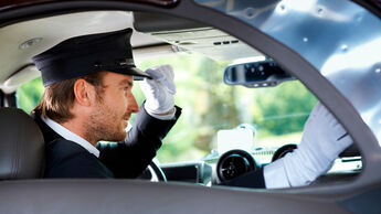 Elegant chauffeur in luxurious car