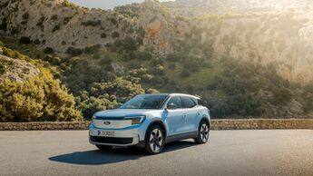 Elektrischer Ford Explorer in blauer Lackierung auf einer Straße vor felsiger Landschaft im Außenaufnahme-Setting.