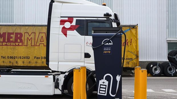 Elektrischer Lkw lädt an einem Ladepunkt auf einem Betriebsgelände