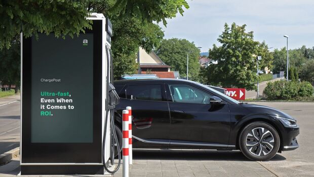 Elektroauto an einem Ladepunkt mit Display-Stele im gewerblichen Umfeld.