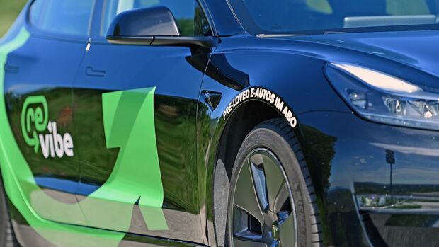 Elektroauto mit Branding von vibe und Hinweis auf „pre-loved e-autos im abo“ an der Fahrzeugseite.