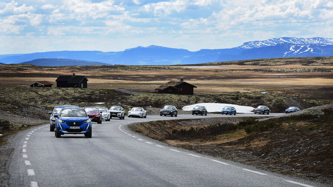 Elektroautos fahren beim NAF El Prix auf einer Straße durch bergiges Gelände in Norwegen.