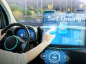 Fahrerin in einem Fahrzeug mit digitalem Cockpit und Anzeigen zu autonomem Fahren sowie Fahrassistenzsystemen auf der Frontscheibe.