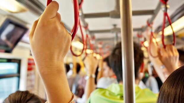 Fahrgäste stehen im Innenraum eines öffentlichen Verkehrsmittels während des Berufsverkehrs.