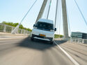 Farizon SV als weißer Elektro-Transporter in Frontansicht auf einer Brücke während der Fahrt.