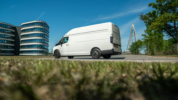 Farizon SV als weißer Elektro-Transporter in Seitenansicht vor einem Gebäude mit Geely-Schriftzug.