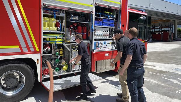Feuerwehrfahrzeug mit geöffneten Geräteräumen bei einer Einweisung.