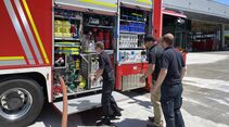 Feuerwehrfahrzeug mit geöffneten Geräteräumen bei einer Einweisung.