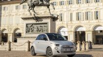 Fiat 500 Hybrid aus der Frontperspektive auf einer Piazza vor historischer Architektur.