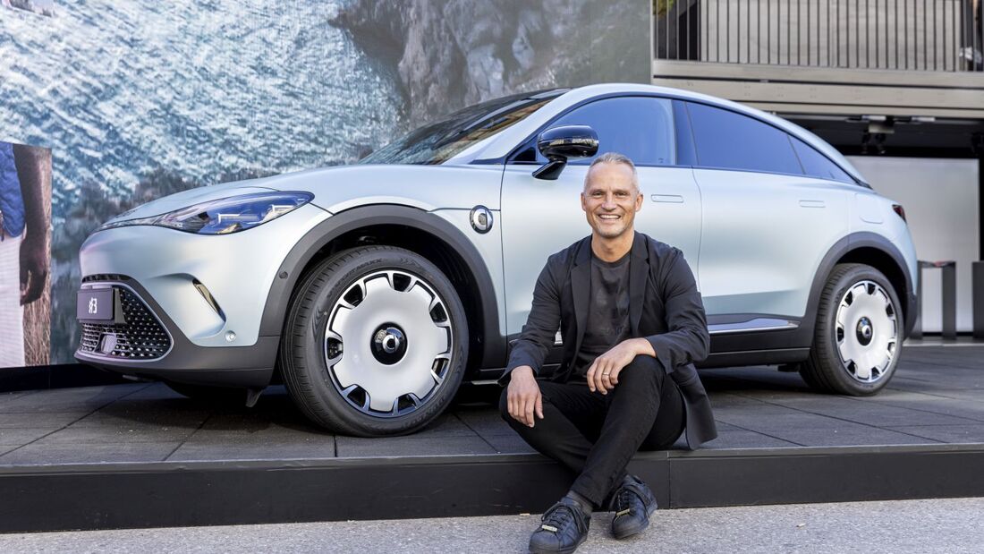 Florian Nemitz sitzt vor einem Smart-Fahrzeug bei einem Termin von smart Deutschland.