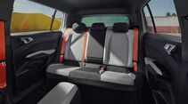 Fond des Skoda Epiq mit drei Rücksitzen, grauen Sitzbezügen, Kopfstützen und roten Sicherheitsgurten.