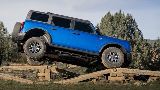 Ford Bronco bei der Auffahrt auf eine hölzerne Offroad-Brücke, Seitenansicht mit erhöhter Vorderachse.