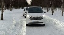Ford E-Transit Custom beim Wintertest auf schneebedeckter Straße, Frontansicht des Fahrzeugs im Testbetrieb.