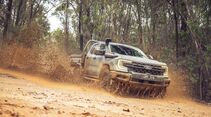 Ford Ranger Super Duty fährt auf schlammiger Offroad-Strecke durch Waldgebiet.