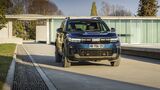Frontansicht des Dacia Bigster auf befestigter Fahrbahn vor modernem Gebäude