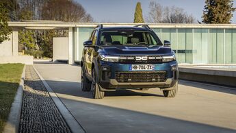 Frontansicht des Dacia Bigster auf befestigter Fahrbahn vor modernem Gebäude