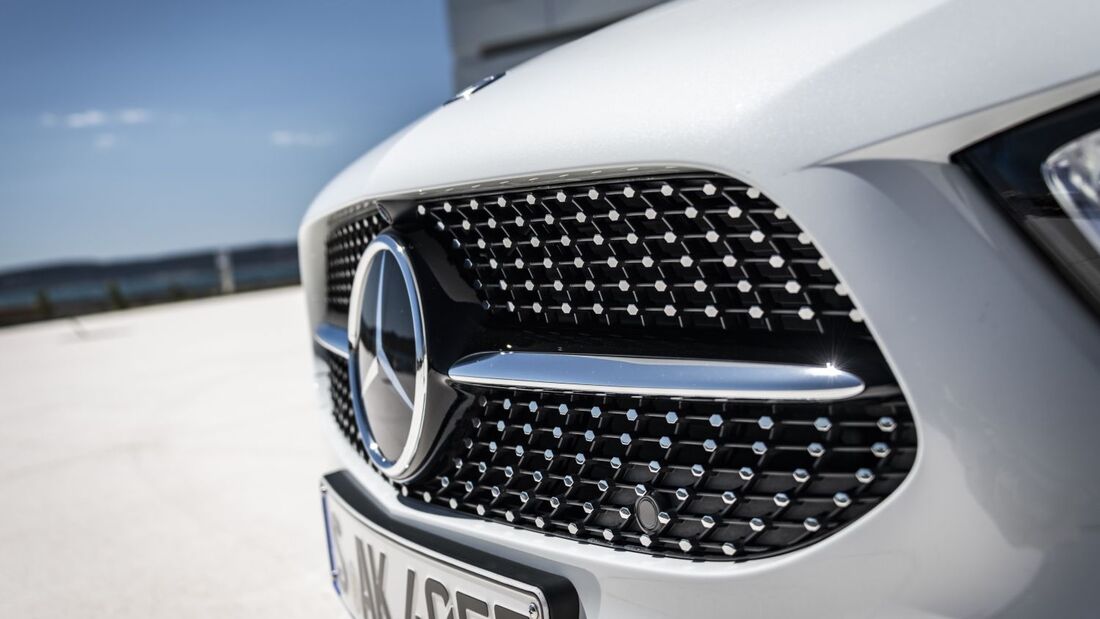 Frontansicht des Kühlergrills einer Mercedes-Benz A-Klasse mit Markenlogo und Diamantstruktur bei Tageslicht.