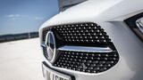 Frontansicht des Kühlergrills einer Mercedes-Benz A-Klasse mit Markenlogo und Diamantstruktur bei Tageslicht.