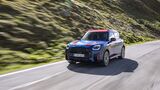 Frontansicht des MINI Countryman JCW auf einer Bergstraße in den Alpen.