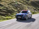 Frontansicht des MINI Countryman JCW auf einer Bergstraße in den Alpen.