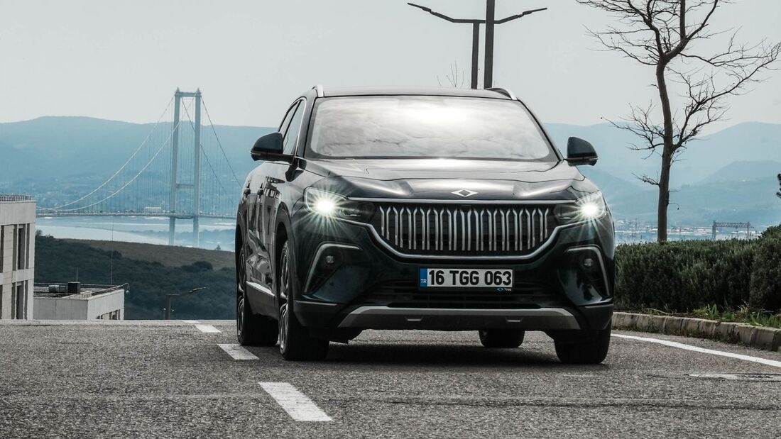 Frontansicht des Togg T10X Elektro-SUV auf asphaltierter Straße mit Brücke im Hintergrund.