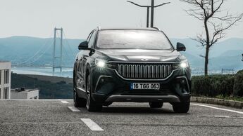 Frontansicht des Togg T10X Elektro-SUV auf asphaltierter Straße mit Brücke im Hintergrund.