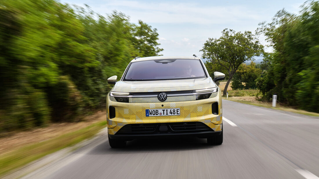 Frontansicht des getarnten VW ID. Tiguan mit Leuchtband, VW-Logo und Wolfsburger Kennzeichen WOB-TI 48E bei der Fahrt auf einer Landstraße