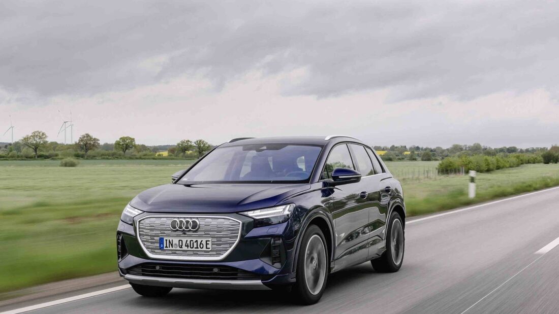 Frontansicht eines Audi Q4 e-tron während der Fahrt auf Landstraße mit geschlossenem Kühlergrill.