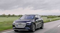 Frontansicht eines Audi Q4 e-tron während der Fahrt auf Landstraße mit geschlossenem Kühlergrill.