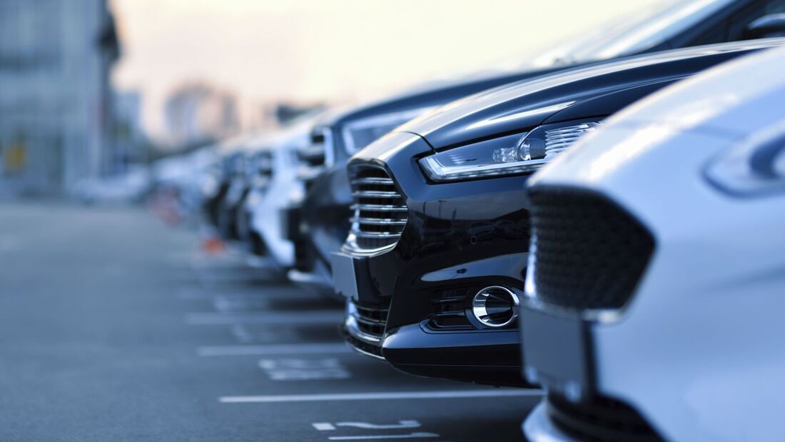 Frontansicht mehrerer Pkw in einer Reihe auf einem Parkplatz als Symbolbild für Unternehmensflotten.