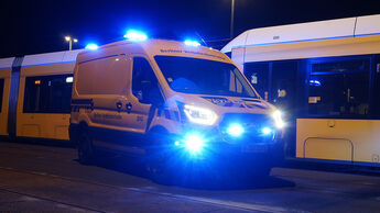 Gelber Ford E-Transit der BVG mit eingeschaltetem Blaulicht vor einem Berliner Linienbus bei Nacht.