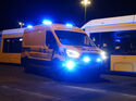 Gelber Ford E-Transit der BVG mit eingeschaltetem Blaulicht vor einem Berliner Linienbus bei Nacht.