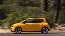 Gelber Renault Twingo E-Tech Electric in Seitenansicht während der Fahrt auf einer Straße.