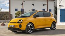 Gelber Renault Twingo E-Tech Elektro-Kleinwagen steht in mediterraner Stadtumgebung.