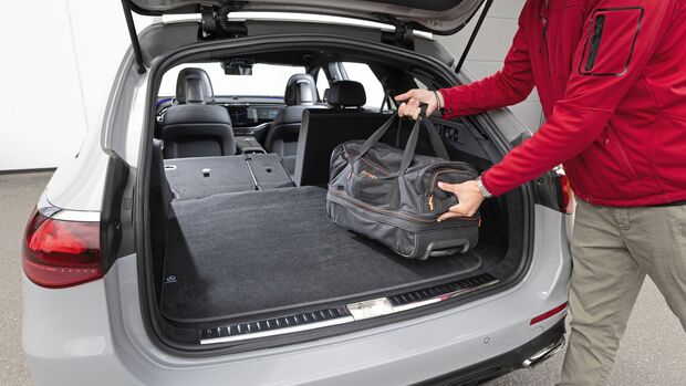 Geöffneter Kofferraum des Mercedes E450 d 4MATIC mit umgeklappten Rücksitzlehnen und Reisetasche auf der Ladefläche.