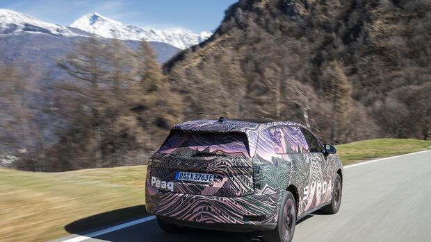 Getarnter Skoda Peaq Prototyp fährt auf Bergstraße mit Alpenlandschaft im Hintergrund