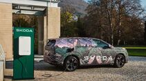 Getarnter Skoda Peaq Prototyp lädt an einer Ladesäule vor Gebäude