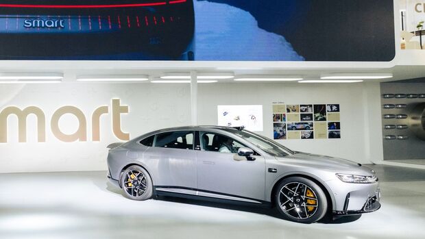 Graue Smart Elektro-Limousine auf Messefläche mit Beleuchtung