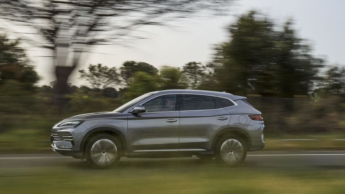 Grauer BYD Seal U DM-i SUV fährt auf Landstraße, Seitenansicht mit Bewegungsunschärfe im Hintergrund.