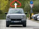 Grauer Elektro-Pick-up Maxus eTerron 9 von vorn, darüber eine rote Cloud mit Upload-Pfeil als Symbol für Datenübertragung zum Hersteller