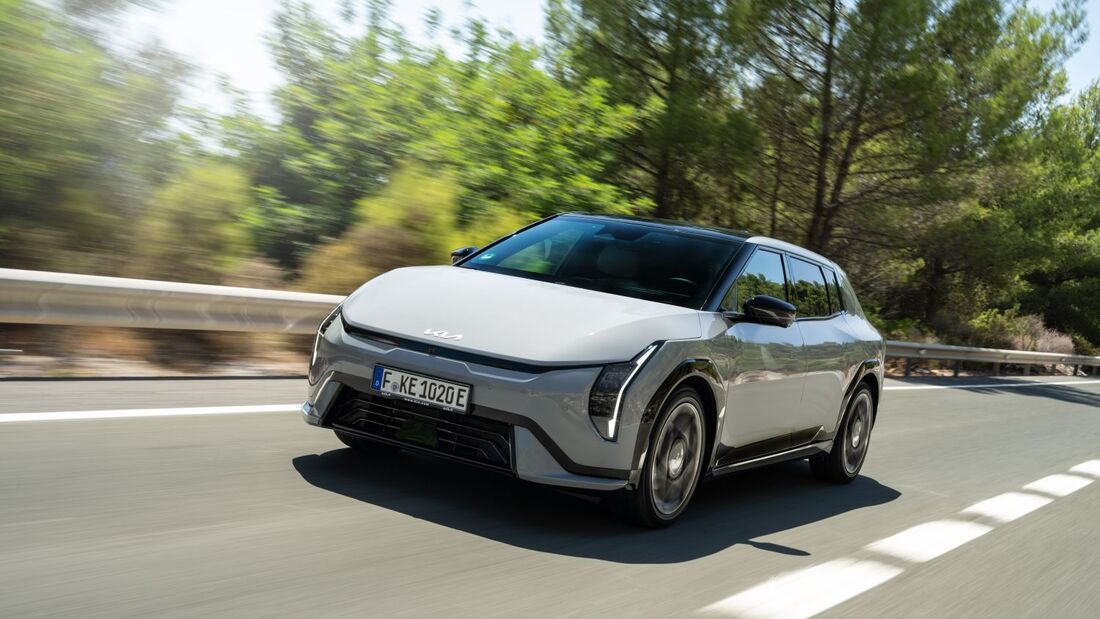 Grauer Kia EV4 GT-Line in Frontansicht während der Fahrt auf einer Straße.