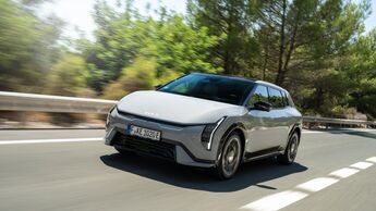 Grauer Kia EV4 GT-Line in Frontansicht während der Fahrt auf einer Straße.
