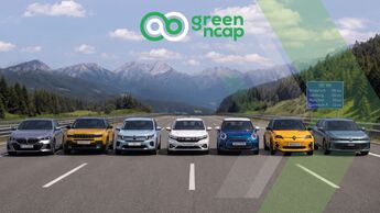 Green-NCAP-Grafik mit sieben getesteten Automodellen auf einer Straße vor Bergkulisse.