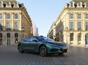 Grüner Denza Z9GT auf einem innerstädtischen Platz. Der Elektro-Grand-Tourer startet für Gewerbekunden ab 599 Euro netto im Leasing.