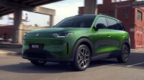 Grüner Leapmotor B03X Elektro-SUV fährt auf einer Straße in urbaner Umgebung mit Brückenbauwerken im Hintergrund.