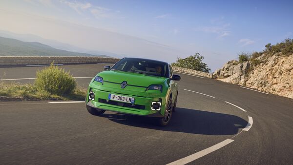 Grüner Renault 5 E-Tech Electric auf kurviger Bergstraße