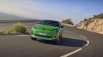 Grüner Renault 5 E-Tech Electric auf kurviger Bergstraße