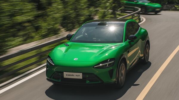 Grüner Xiaomi YU7 in Frontansicht während der Fahrt auf einer kurvigen Straße.