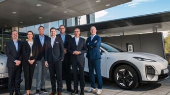Gruppenfoto von Führungskräften von Changan, Arval Deutschland und Consors Finanz vor einem Elektrofahrzeug.